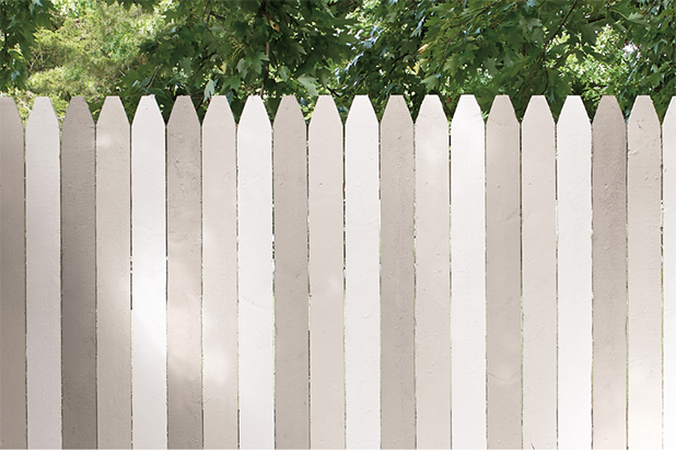 A picket fence is painted three alternating colors of white, off-white and grey.