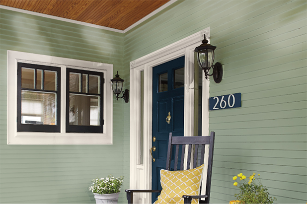 Side angle of the front door of a house with a front door and teal siding.