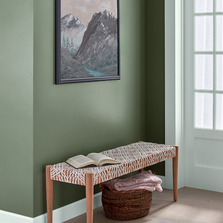 Entryway with modern bench seat. Framed art hangs on the wild basil colored wall.