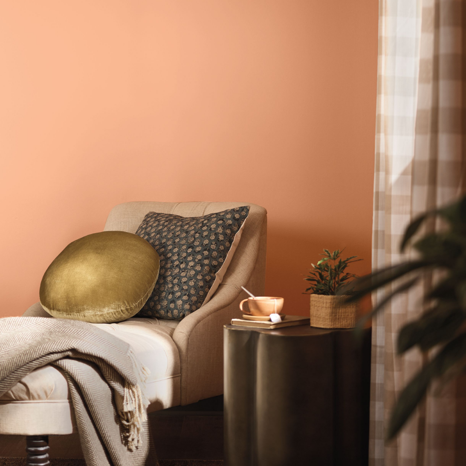  A chair next to a side table. Walls are painted in the color painted wild orange.