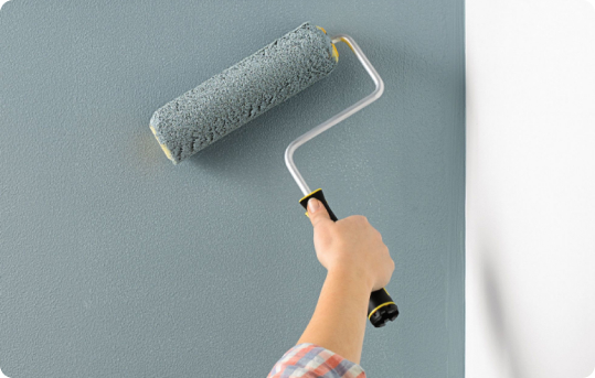 person rolling paint on a wall