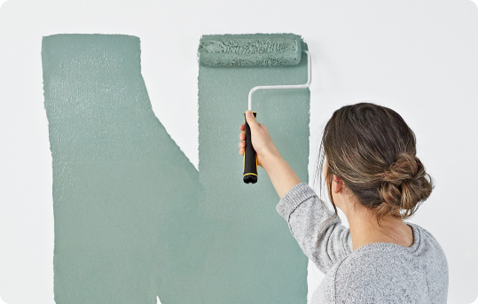 person rolling paint on a wall