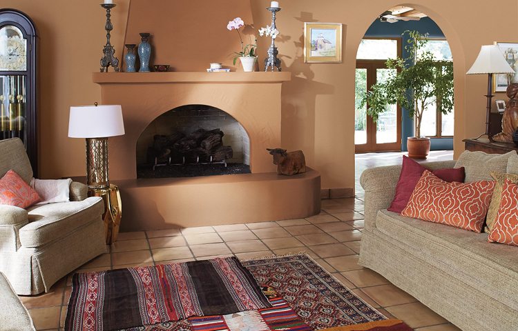 Living room with arched doorway and fireplace, a cozy couch with coffee table. Walls are painted in the color sweetened tea. 