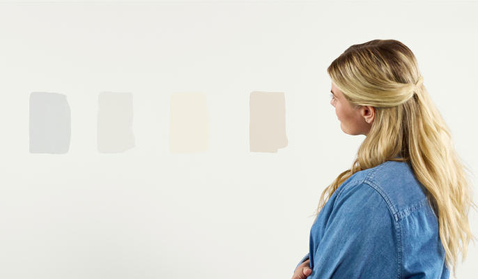 Person looking at swatches of color on a wall