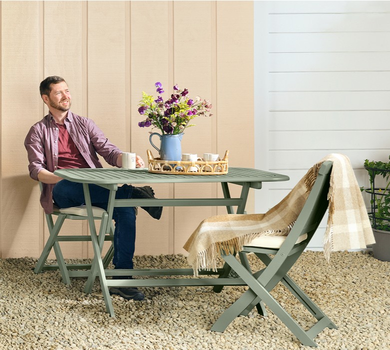 Color of the year color trend - Rekindle. Outside porch with man sitting at a table.