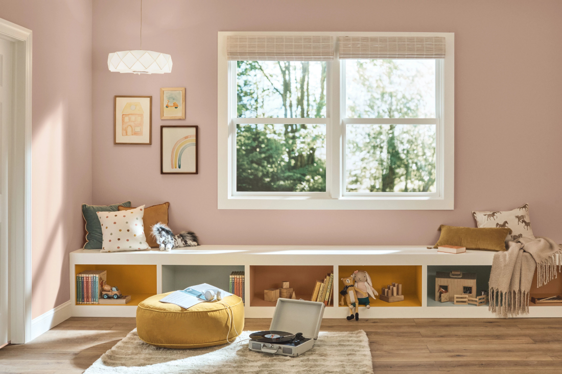 A sunny indoor children’s playroom with built-in bench. Walls are painted neutral mauve mystery.