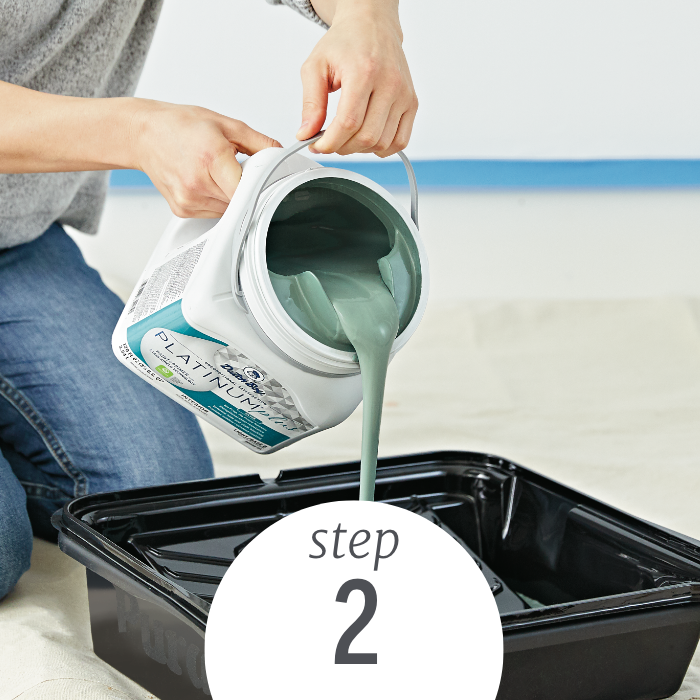 A woman pours Dutch Boy Platinum Paint into a paint tray in preparation to paint.