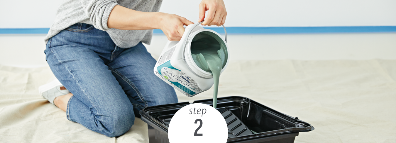 A woman pours Dutch Boy Platinum Paint into a paint tray in preparation to paint.