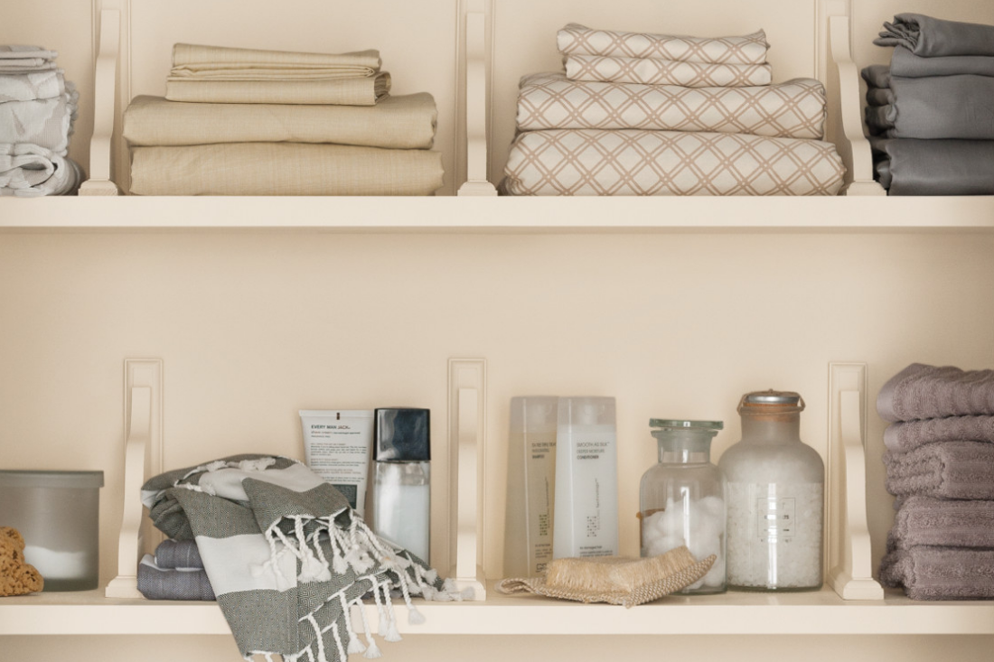 Built-in wood shelving in a linen closet, painted in the color dust flats. 