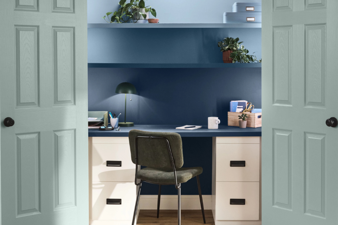 A home office inside a closet with peridot sparkle doors. Wall and shelves in office are midnight bliss and brookside blue.