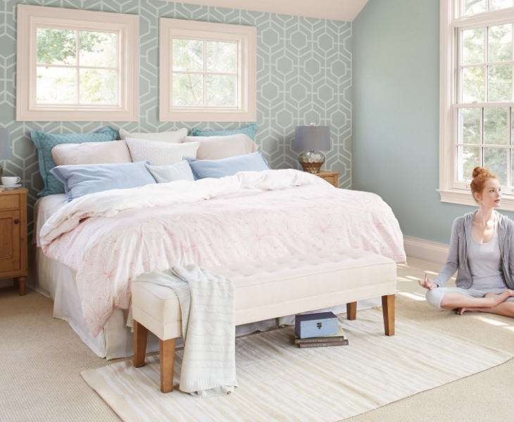 bedroom with bed and person in yoga pose