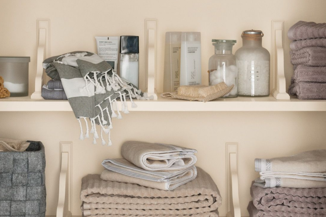 Built-in wood shelving in a linen closet, painted in the color dust flats. 