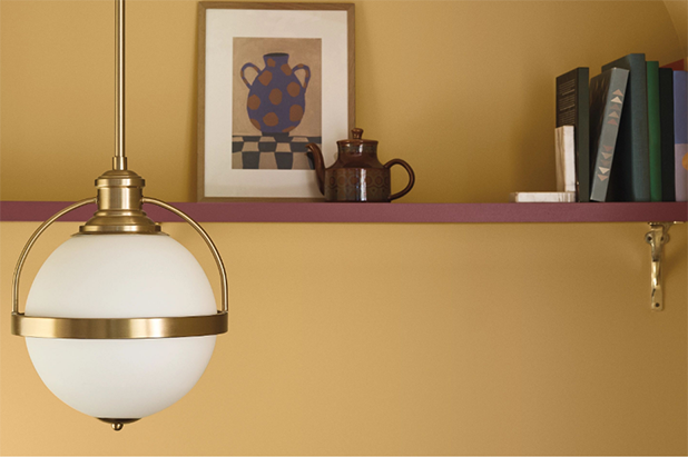 High shelf in breakfast nook. Walls painted a warm yellow, shelf is painted maroon. 