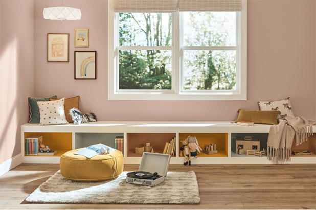 A sunny indoor children’s playroom with built-in bench. Walls are painted neutral mauve mystery.