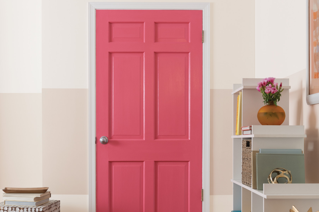 Modern-styled living room with a red door and a pale colored wall with a beige stripe across it.