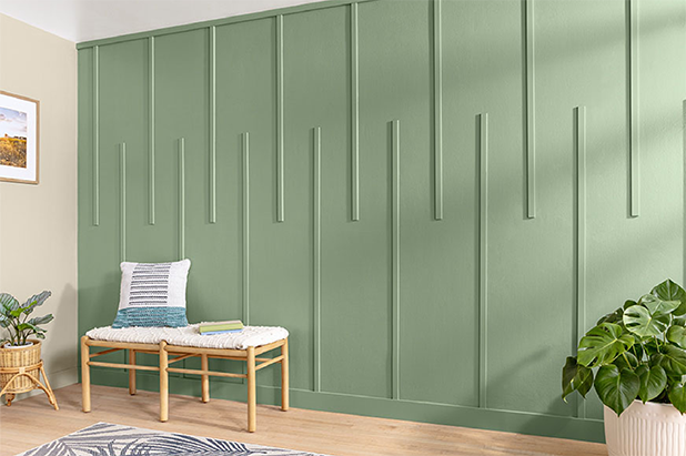 Entryway wall has patterned wood slats painted light green, with sitting bench, potted plants and patterned area rug.