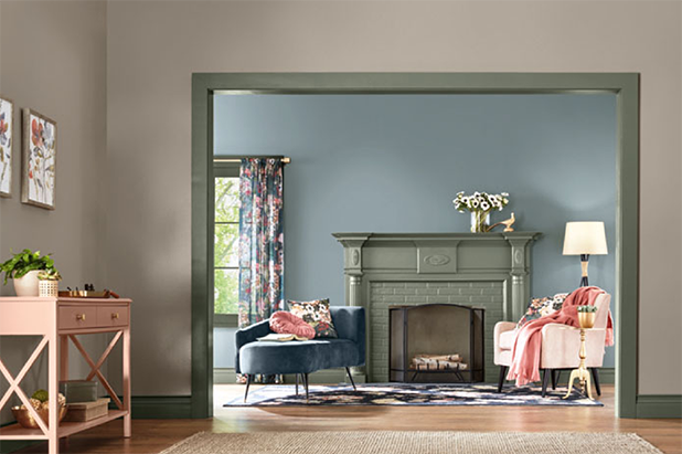 Entry way painted grey with olive moss trim opening to a living room with a matching olive moss fireplace and blue walls.