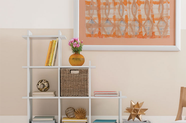 Living room with wild orange walls, a window with a misty mountain view and cozy chaise lounge with side table.