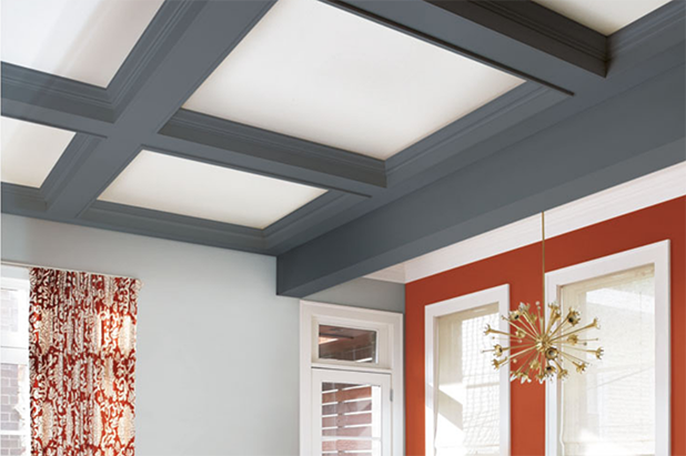 High vaulted ceilings of a living room. White ceiling with beams painted the color charcoal black.