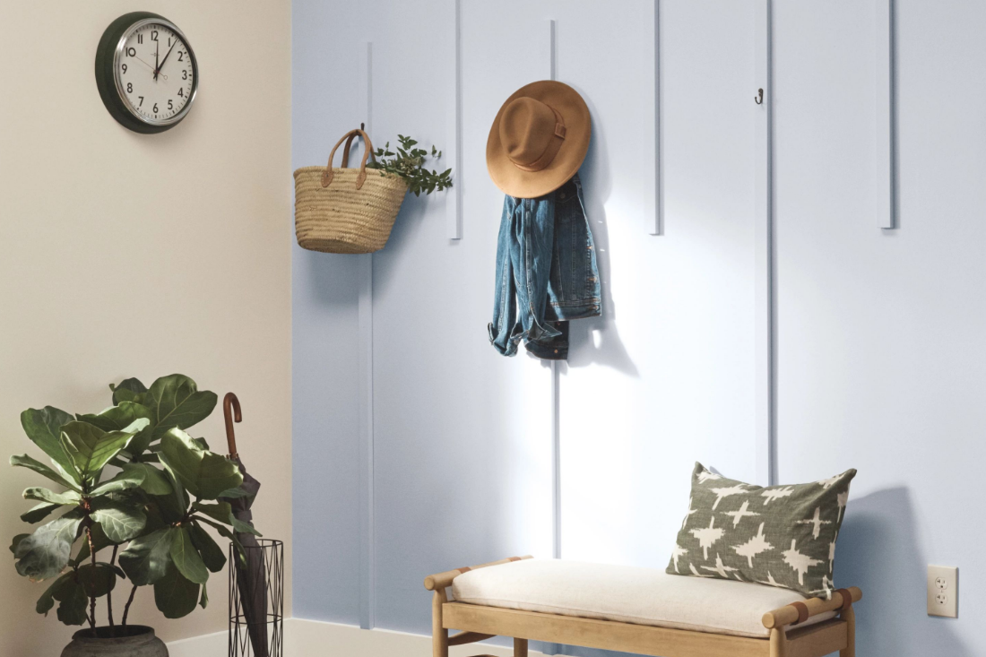 painted entryway with bench and hooks for hats and coats