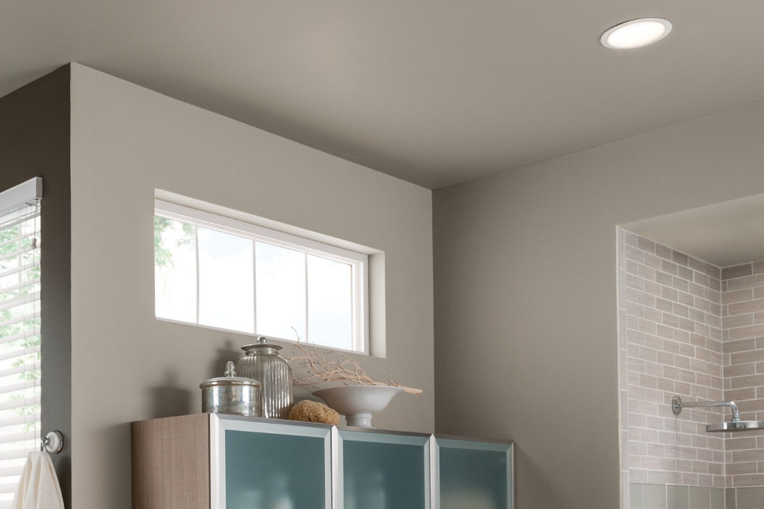A bathroom with tile shower and windows. Wall-to-ceiling painted the color of dusky gray to make the ceiling feel high. 