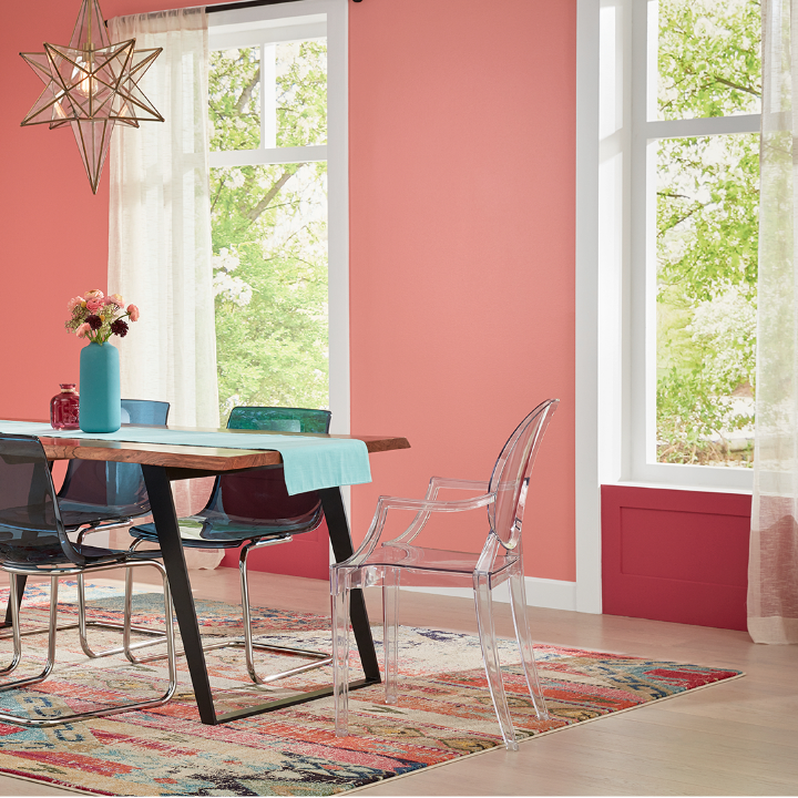 Open dining room with a dining room table and modern chairs surrounding it. Walls painted the color rose window.