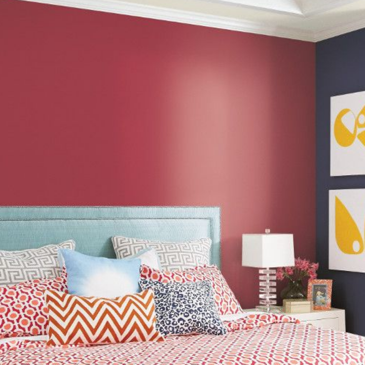 red walls in a bedroom with bed and lamp
