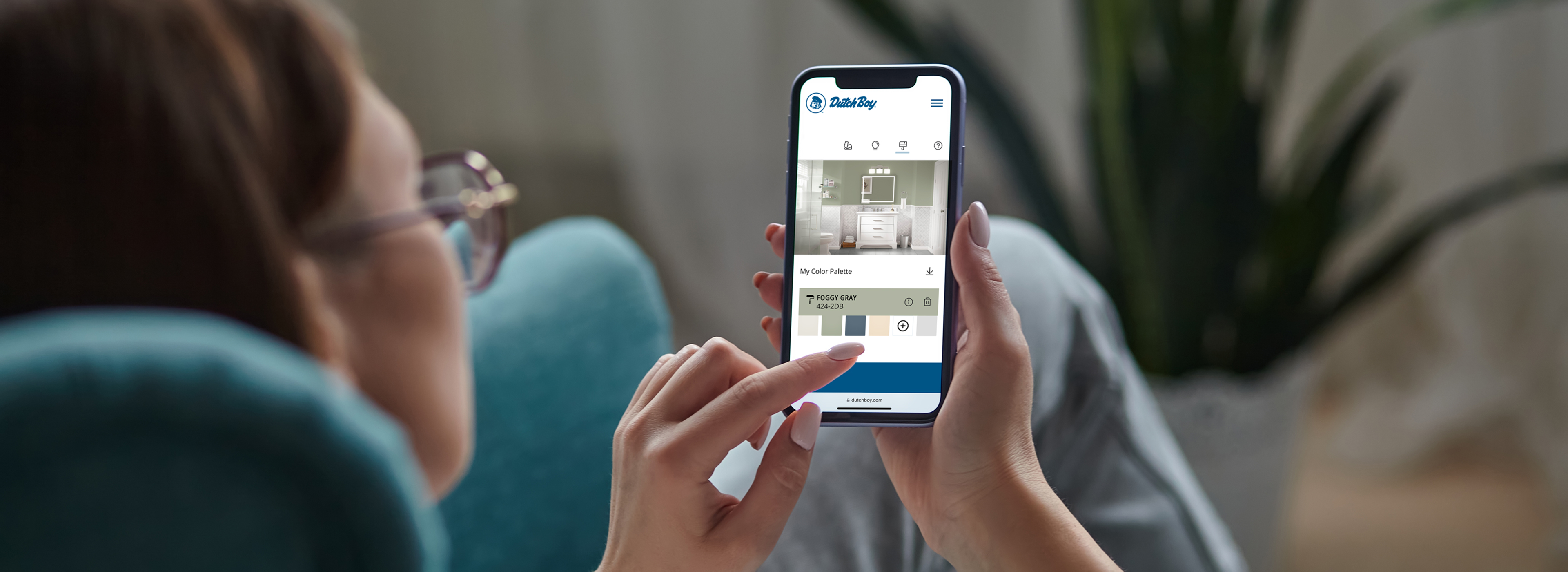 Woman using a color visualizer tool on her phone to see how a bathroom would look in Dutch Boy Foggy Gray color.