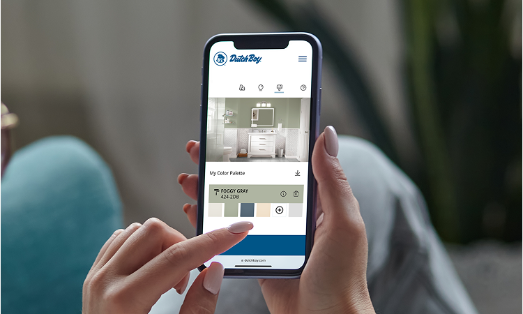 Woman using a color visualizer tool on her phone to see how a bathroom would look in Dutch Boy Foggy Gray color.