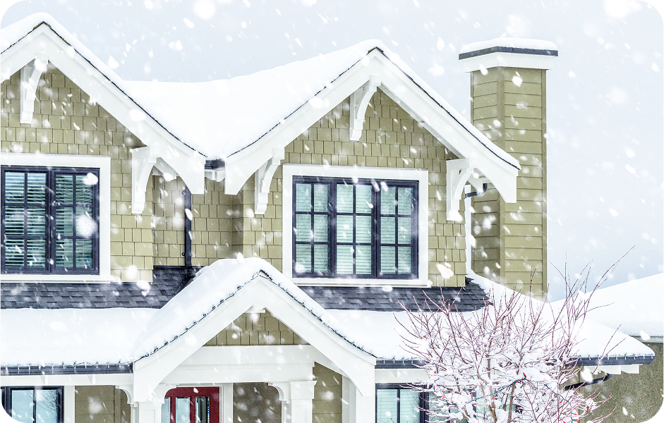 Exterior of a home in the winter with falling snow.