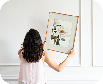 Woman taking heavy artwork off a white wall with wainscoting showing no scuffing or scratches are left behind.