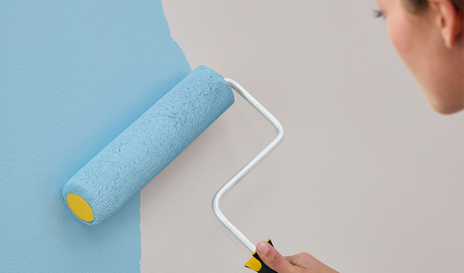 person rolling paint on a wall