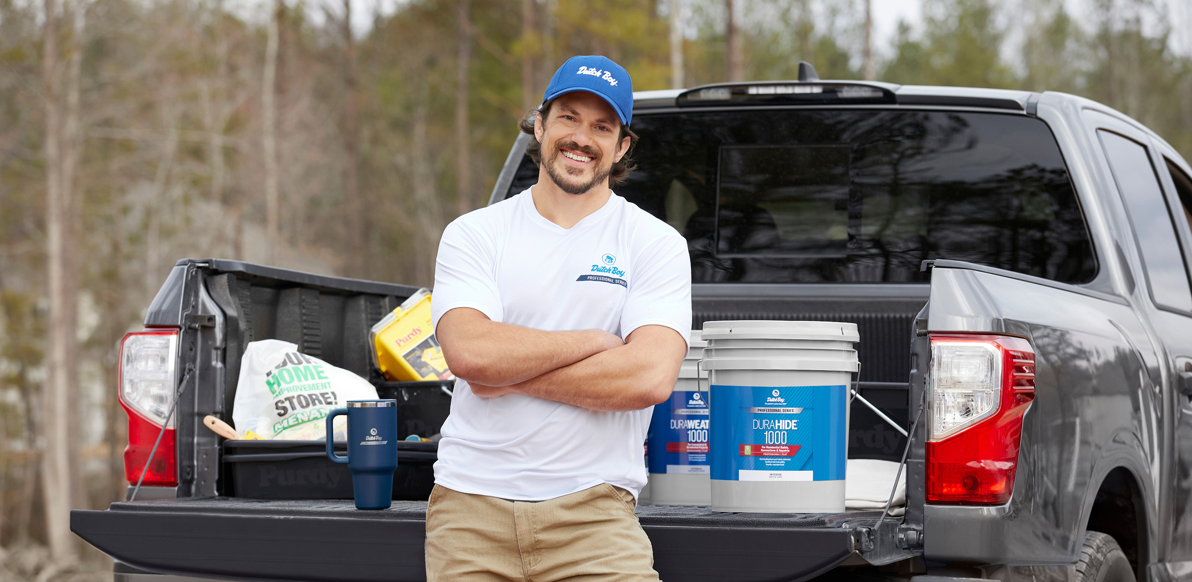 Pro in front of pickup with 5 gallon buckets of Dutch Boy Professional Series paint in bed.