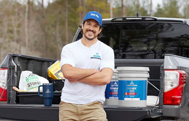 Pro in front of pickup with 5 gallon buckets of Dutch Boy Professional Series paint in bed.