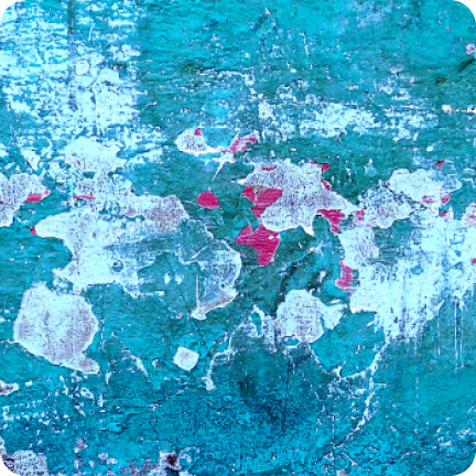 A wall painted light blue long ago is showing signs of stains, chalk marks and mildew.