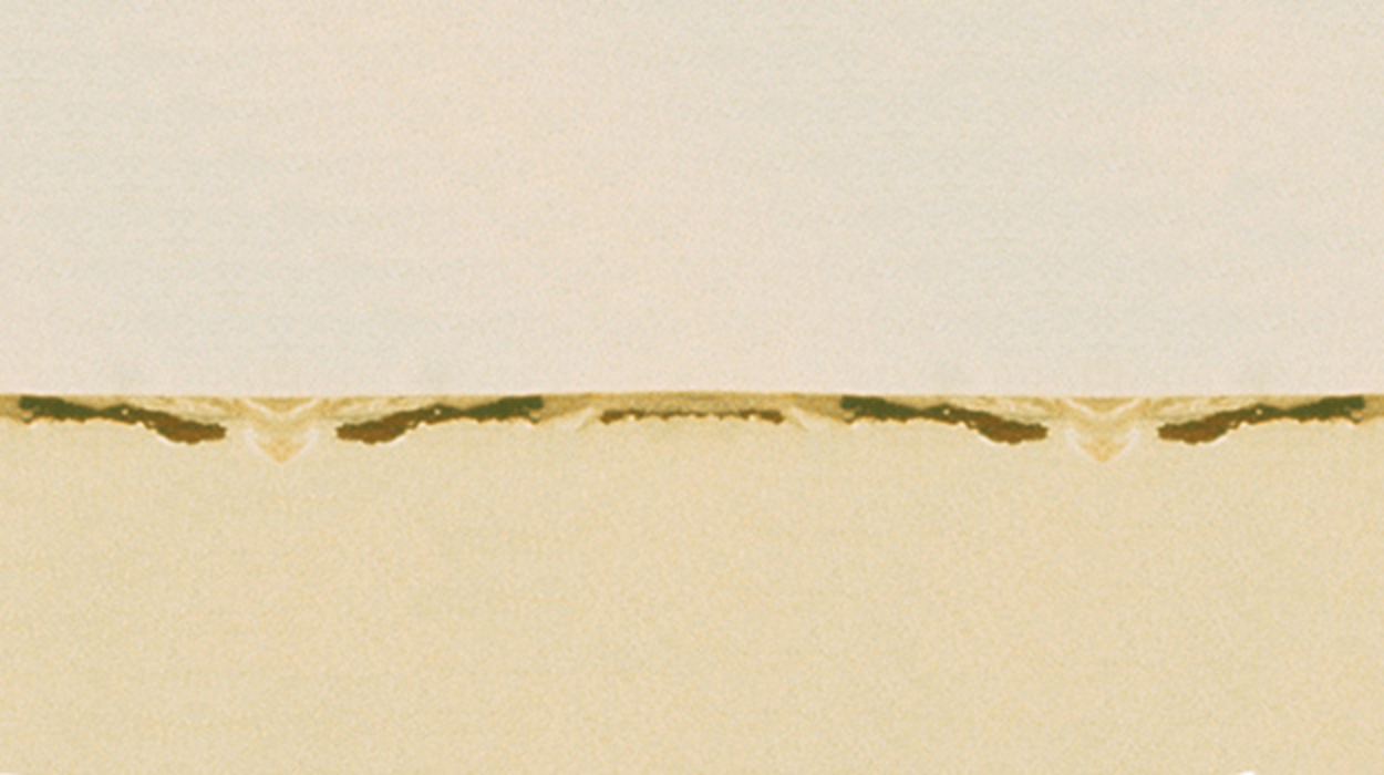 A wall painted beige long ago is showing signs of blocking.